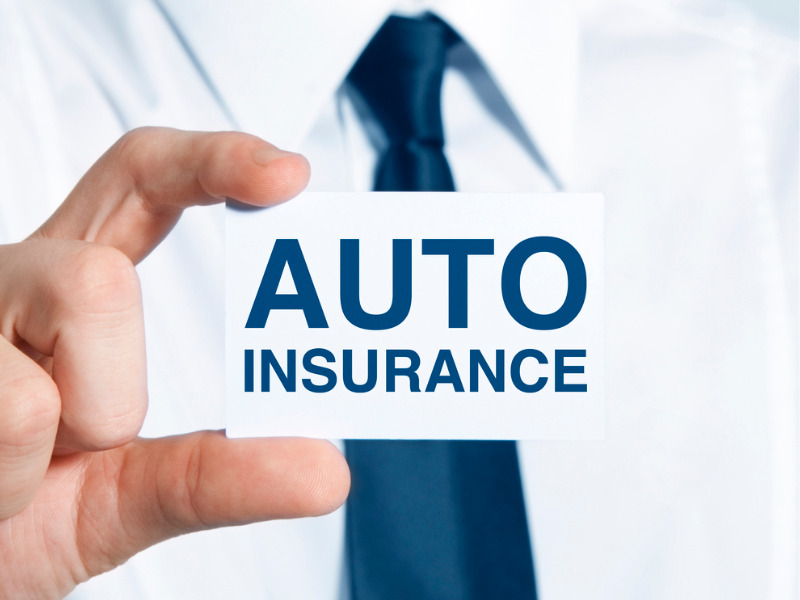 Insurance salesman holding a card with the words 'auto insurance.'